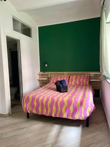 a bedroom with a bed with a green wall at Casa Vale Parco del Valentino in Turin
