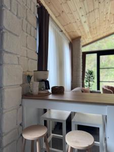 a kitchen with two stools and a counter and a brick wall at Villa Del Rio Karadeniz River Palace Ayder in Çamlıhemşin