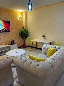 a living room with a couch and a table at Executive Cozy Furnished Apartment-In Utawala, NBO, Near JKIA in Nairobi