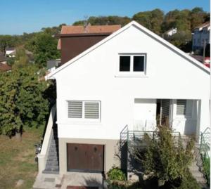 a white house with a garage at Magnifique Villa le89golden jacuzzi et sauna privatif in Mulhouse