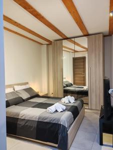 ein Schlafzimmer mit einem großen Bett und einem Spiegel in der Unterkunft Etna Garden House: Oasis in the heart of Catania in Catania
