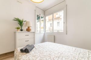 a white bedroom with a bed and a window at VALLH in Barcelona