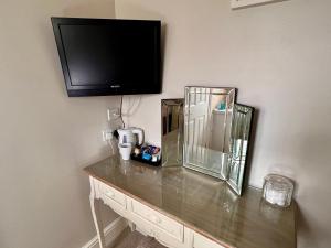 a room with a counter with a tv on the wall at The Mayfair guest house self catering in Southampton