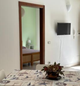 Una habitación con una mesa con un jarrón de flores. en Il Poggio del Cilento Country House, en Agropoli
