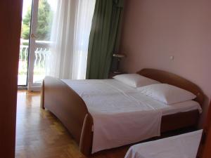 a bed in a bedroom with a large window at Apartments Happy Island Rab in Rab +49 photos