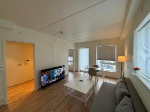 a living room with a couch and a flat screen tv at New Modern Apartment in Central Jessheim in Jessheim