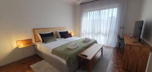 - une chambre avec un grand lit et une fenêtre dans l'établissement Azurara Guesthouse, à Azurara