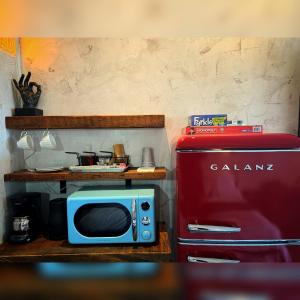 a microwave and a red refrigerator in a kitchen at Neon Cowboy Roadhouse at Hunters Hot Springs in Lakeview
