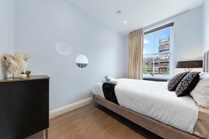 um quarto com uma cama e uma grande janela em Stunning 1 bedroom in Westminster with AC sleeps 4 em Londres