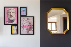 un grupo de cuadros enmarcados en una pared con un espejo en One Suite, en Ascea