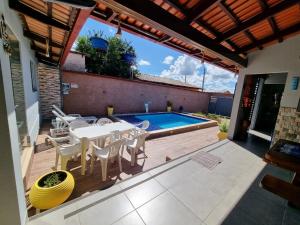 een patio met een tafel en stoelen en een zwembad bij Pouso da Kakau in Pirenópolis