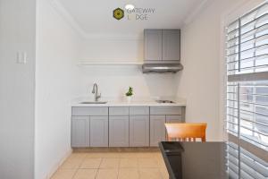 a kitchen with a sink and a table and a chair at Gateway Lodge in Seaside