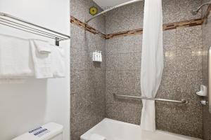 a bathroom with a shower with a toilet and a shower curtain at Gateway Lodge in Seaside +37 photos