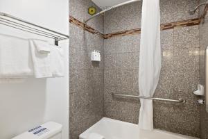 a bathroom with a shower with a toilet and a shower curtain at Gateway Lodge in Seaside