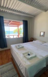 a bedroom with a bed with two towels on it at Casuarinas del Mar Habitacion Playa in Canoas De Punta Sal