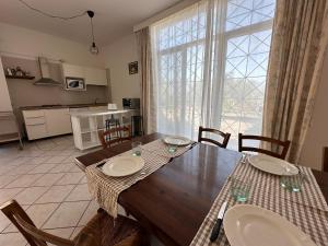 Antica Sorgente villa في أغروبولي: مطبخ وغرفة طعام مع طاولة خشبية مع كراسي