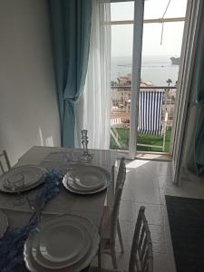 a dining room table with a view of the ocean at Blue Eyes L'INCANTESIMO SUL MARE in Gaeta