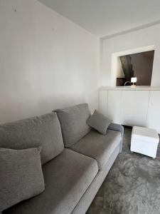 uma sala de estar com um sofá cinzento e uma parede branca em La Casita Hermosa em Alicante