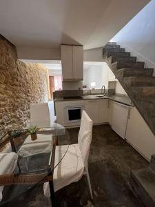 uma cozinha com uma mesa de vidro e uma escada em La Casita Hermosa em Alicante