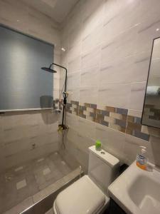 uma casa de banho com um WC branco e um lavatório. em Amazing Grace Apartment em Cape Coast