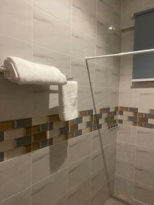 uma casa de banho com um chuveiro e 2 toalhas numa parede em Amazing Grace Apartment em Cape Coast