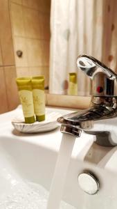 a bathroom sink with two cups on top of it at H&H cozy retreat ,Fireplace and Parking in Piraeus +22 photos