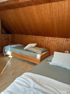 2 Betten in einem Zimmer mit Holzwänden in der Unterkunft Casita grün in Worms