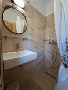 een badkamer met een wastafel en een spiegel bij Gongis Studios in Agios Georgios