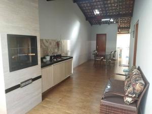 a living room with a couch and a kitchen at Casa completa em Ituiutaba Ar condicionado in Ituiutaba