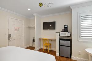 a bedroom with a bed and a desk with a microwave at Gateway Lodge in Seaside