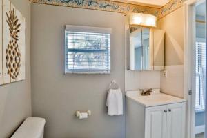a bathroom with a sink and a toilet and a window at Summer Sands Lodge Unit 2 in Flagler Beach