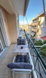 a balcony with a couch and a table on a building at H&H cozy retreat ,Fireplace and Parking in Piraeus