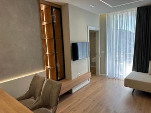 a living room with a tv and a couch and chairs at Sea Scape Apartment 3 in Vlorë