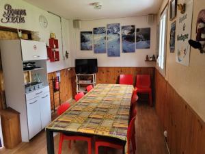comedor con mesa y sillas rojas en Gîte Espace et Montagne, en Aragnouet