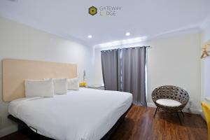 a bedroom with a large white bed and a chair at Gateway Lodge in Seaside