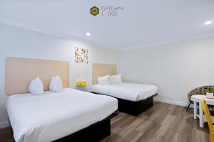 a hotel room with two beds and a table at Gateway Lodge in Seaside