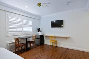 a room with a table and chairs and a tv on the wall at Gateway Lodge in Seaside
