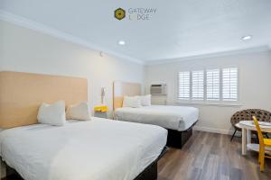 a bedroom with two beds and a table and a window at Gateway Lodge in Seaside