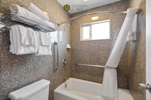 a bathroom with a toilet and a shower with towels at Gateway Lodge in Seaside