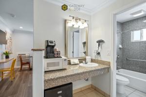 a hotel bathroom with a sink and a microwave at Gateway Lodge in Seaside