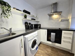 a kitchen with a washing machine and a sink at 2BD Kings Cross & St Pancras Elegance in London