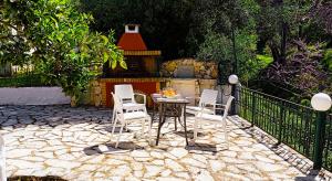a table and four chairs on a stone patio at The Old Well, Spacious House in North Corfu in Perítheia