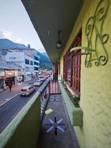 a view of a city street with cars parked on the road at Garden House Hostal in Baños