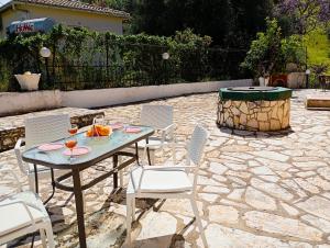 a table and chairs on a stone patio at The Old Well, Spacious House in North Corfu in Perítheia