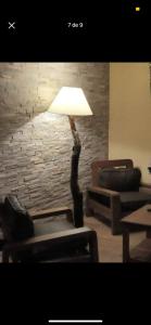 lámpara en la sala de estar con silla y sofá en La Caprichosa, en San Luis