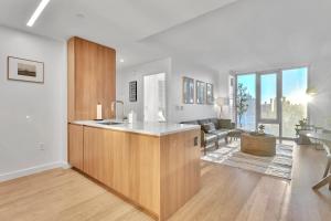a kitchen with a counter and a living room at Prime NYC Waterfront Gem in Mott Haven