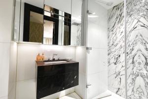een badkamer met een zwarte wastafel en een spiegel bij Luxury-high street Kensington-spacious-hydePark in Londen