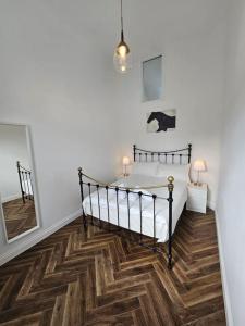 a bedroom with a bed and a wooden floor at Charming House in City Centre in Dublin