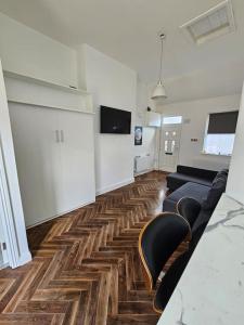 a living room with a couch and chairs on a wooden floor at Charming House in City Centre in Dublin