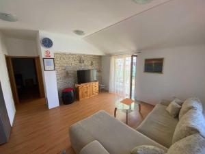 a living room with a couch and a tv at Apartment With the Sea View in Basina